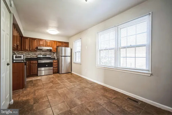 a large kitchen with stainless steel appliances granite countertop a stove and a refrigerator