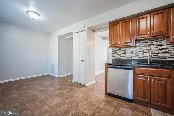 a kitchen with granite countertop wooden cabinets stainless steel appliances a sink and a window