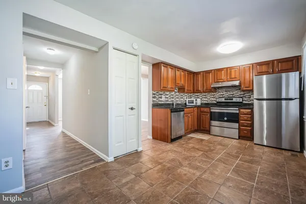 a kitchen with stainless steel appliances granite countertop a refrigerator and a stove top oven