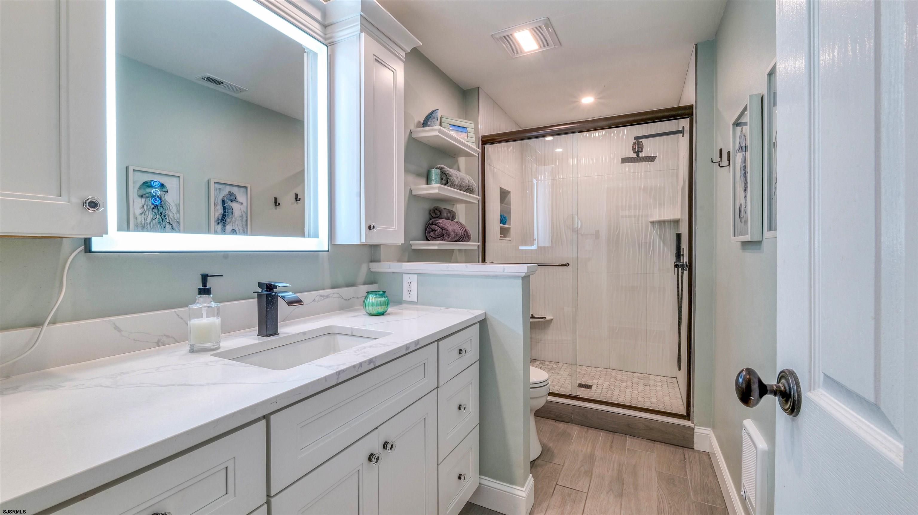 525 Lagoon Boulevard Brigantine, NJ 08203 - Photo 23 of 52 a bathroom with a granite countertop sink mirror vanity and a shower