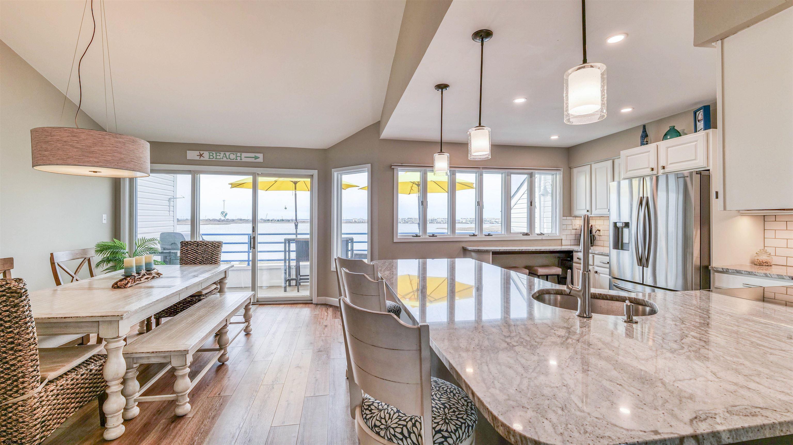 525 Lagoon Boulevard Brigantine, NJ 08203 - Photo 35 of 52 a kitchen with stainless steel appliances kitchen island granite countertop a stove a refrigerator a oven with white cabinets and wooden floor