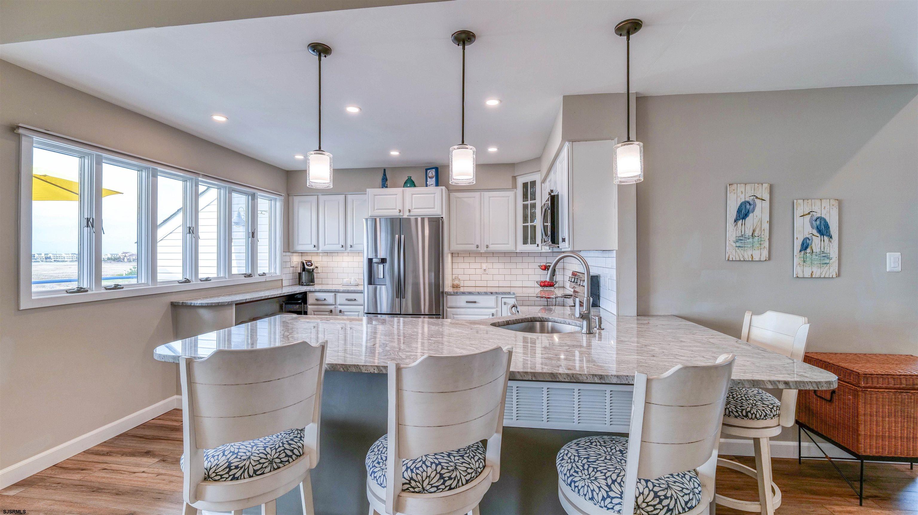 525 Lagoon Boulevard Brigantine, NJ 08203 - Photo 41 of 52 a dining room with furniture and a chandelier
