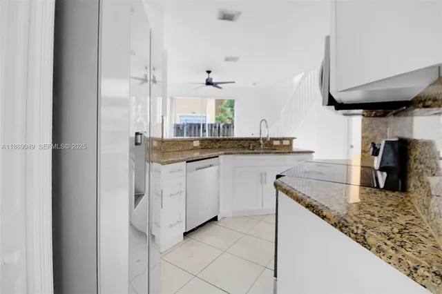 a kitchen with white cabinets and sink