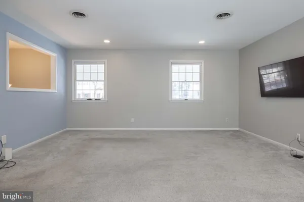 a view of a big room with wooden floor and windows