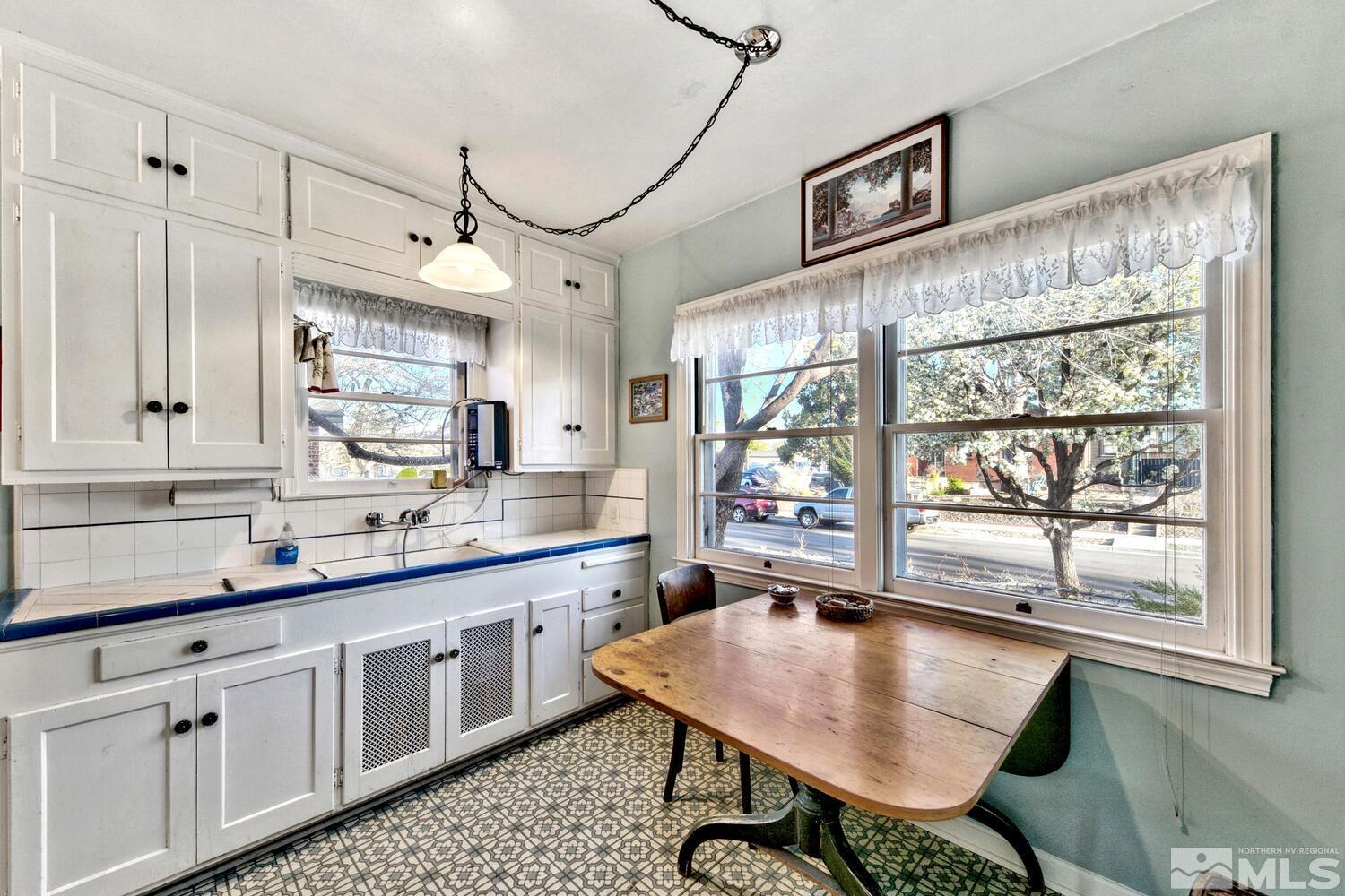561 Moran Street Reno, NV 89502 - Photo 6 of 40 a kitchen with stainless steel appliances granite countertop a sink dishwasher a stove a dining table and chairs with wooden floor