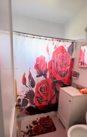 a bathroom with a toilet and a shower curtain