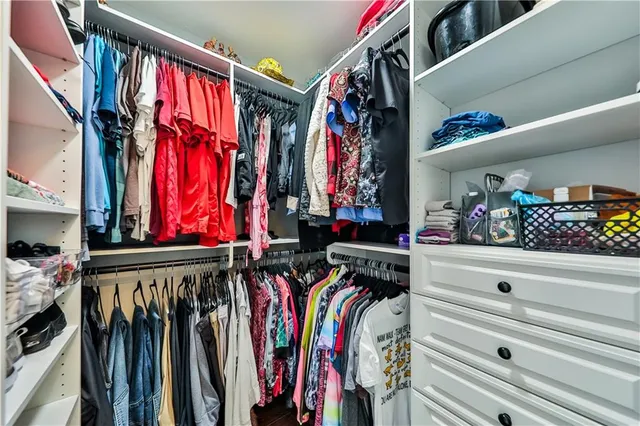 a view of walk in closet with clothes