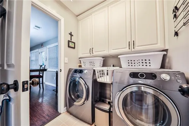a utility room with dryer washer and a view of living room
