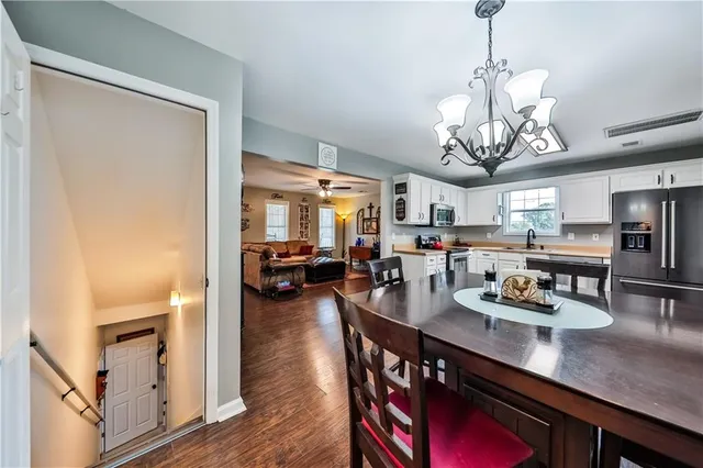a view of a dining room and livingroom with furniture wooden floor a chandelier