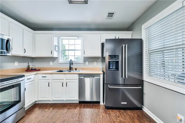 a kitchen with stainless steel appliances granite countertop a refrigerator and a stove top oven