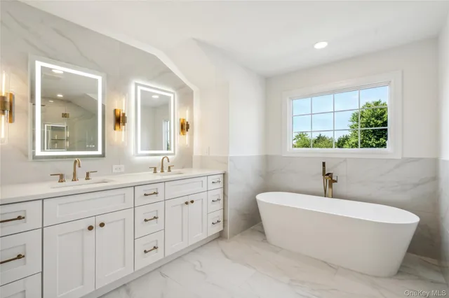 a bathroom with a double vanity sink a mirror and a bathtub