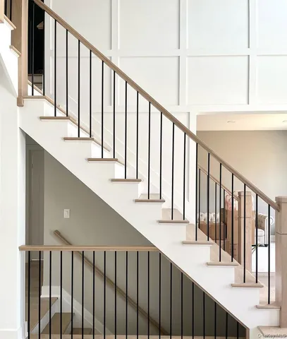 a view of staircase with railing and a window
