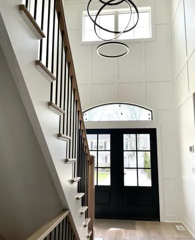 a view of staircase with railing and chandelier