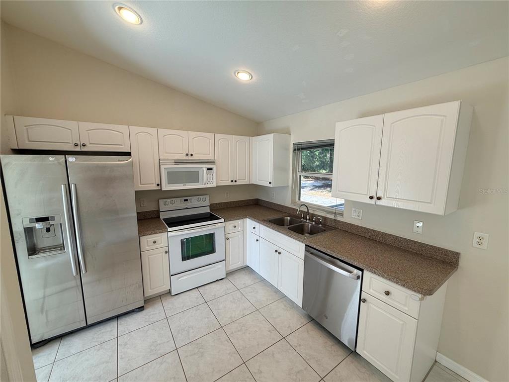 4185 Amari Road North Port, FL 34291 - Photo 7 of 14 a kitchen with granite countertop white cabinets and white appliances