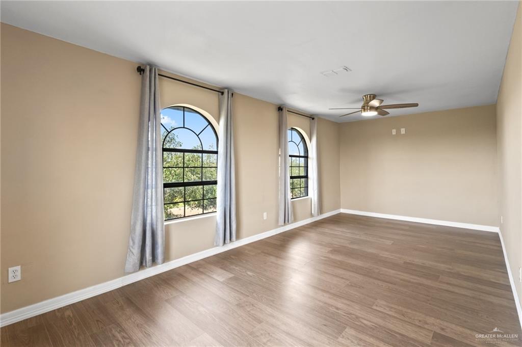 8006 Senecio Street Mission, TX 78574 - Photo 11 of 20 a view of an empty room with wooden floor and a window