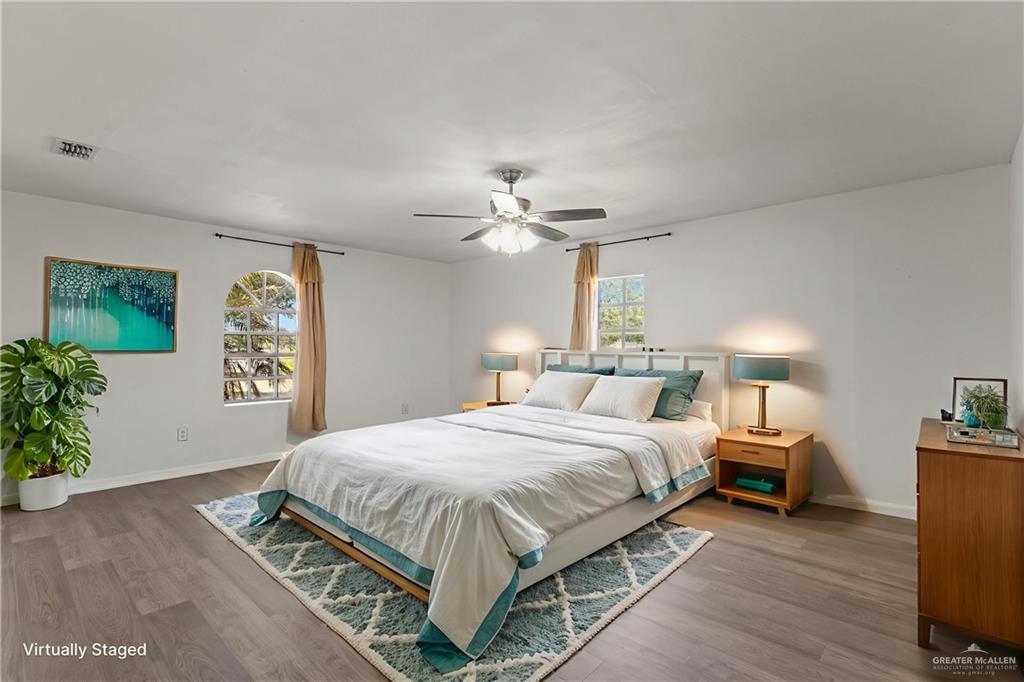 8006 Senecio Street Mission, TX 78574 - Photo 13 of 20 a bedroom with a bed and a chandelier
