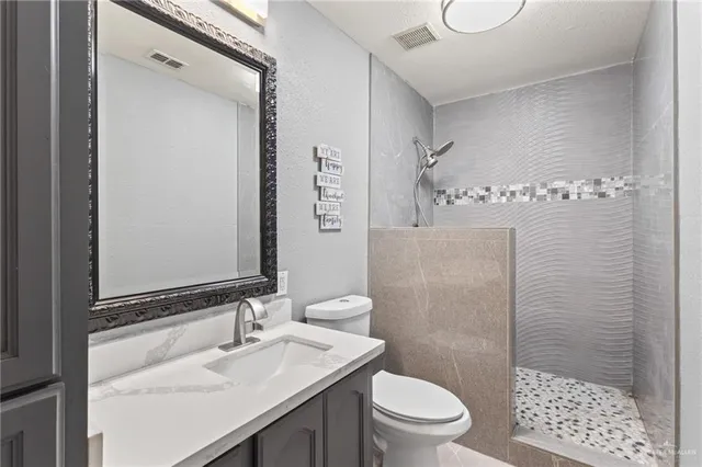 a bathroom with a sink a toilet and shower