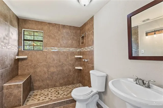 a bathroom with a sink a toilet and shower