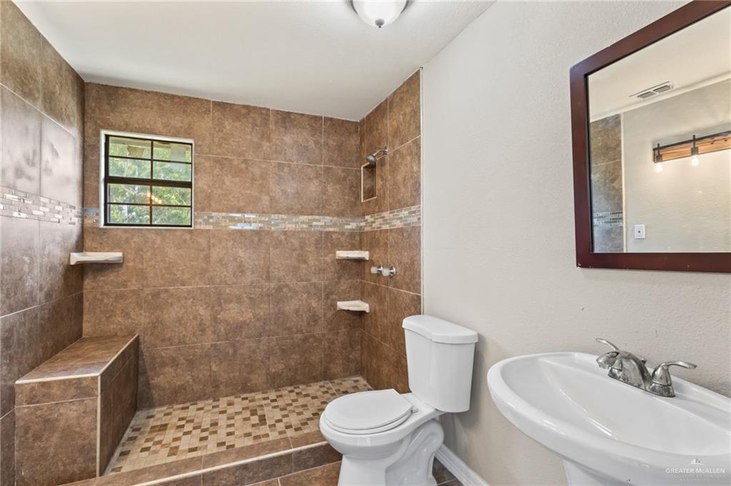 8006 Senecio Street Mission, TX 78574 - Photo 10 of 20 a bathroom with a sink a toilet and shower