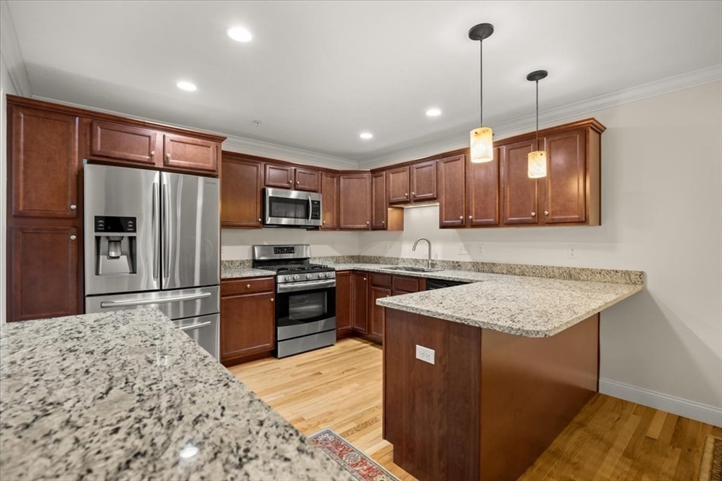 22 Highland Road, Unit 29 Raynham, MA 02767 - Photo 16 of 36 a kitchen with stainless steel appliances granite countertop a sink refrigerator and microwave