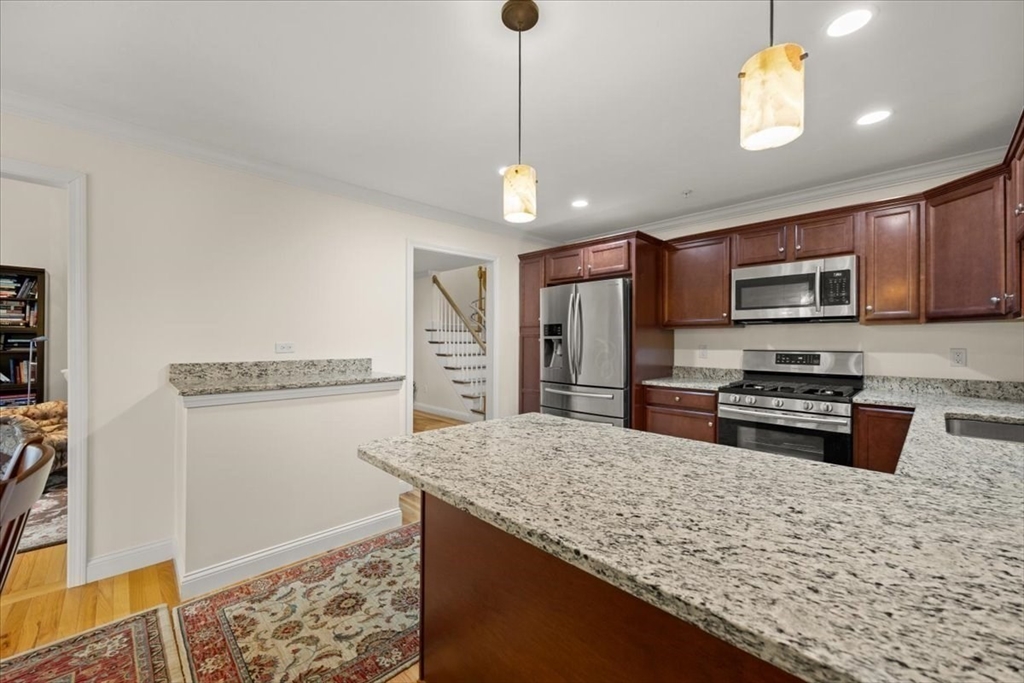 22 Highland Road, Unit 29 Raynham, MA 02767 - Photo 17 of 36 a kitchen with stainless steel appliances granite countertop a refrigerator a stove a sink dishwasher a oven with a dining table and chairs