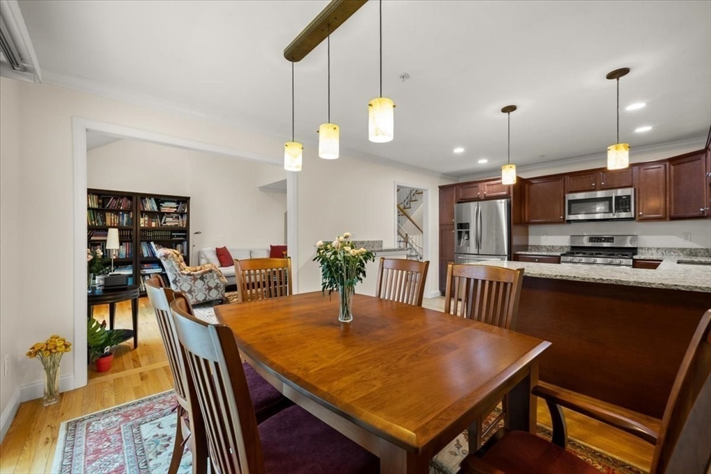 22 Highland Road, Unit 29 Raynham, MA 02767 - Photo 21 of 36 a kitchen with stainless steel appliances granite countertop a dining table chairs refrigerator and microwave