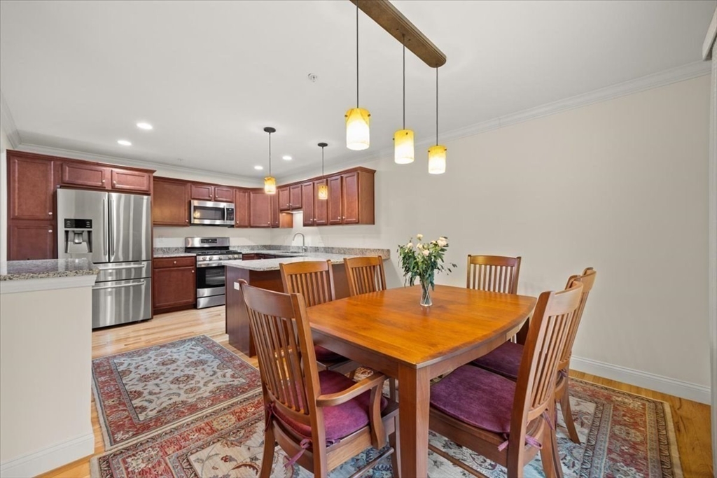 22 Highland Road, Unit 29 Raynham, MA 02767 - Photo 22 of 36 a kitchen with stainless steel appliances kitchen island granite countertop a table chairs and a refrigerator