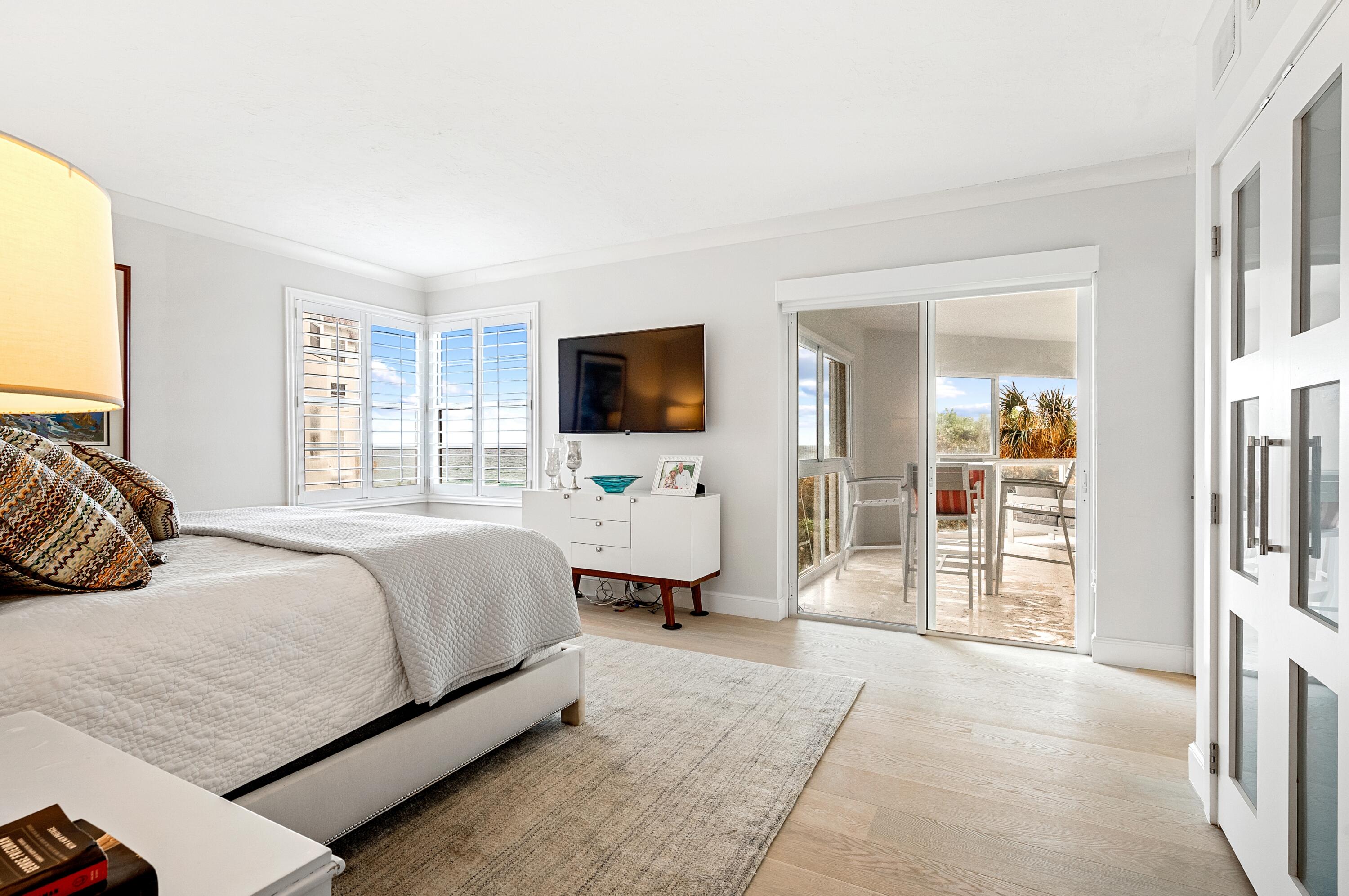 6665 North Ocean Boulevard, Unit C3 Ocean Ridge, FL 33435 - Photo 7 of 19 a bedroom with a large bed and a flat tv screen on dresser