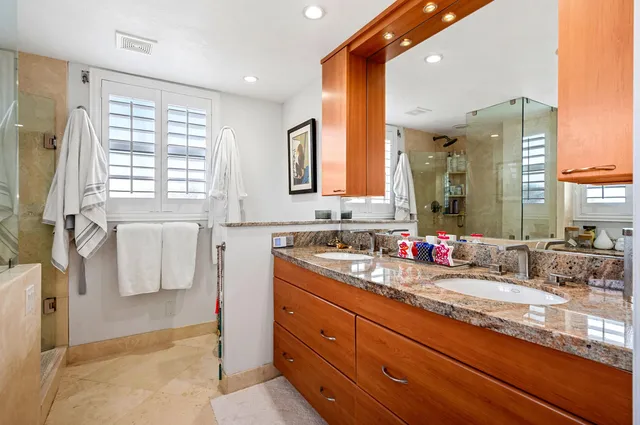 a bathroom with a granite countertop sink mirror and a bathtub