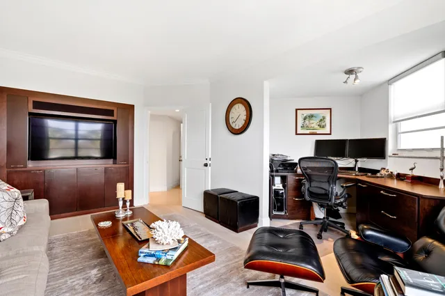 a living room with furniture a flat screen tv and a window