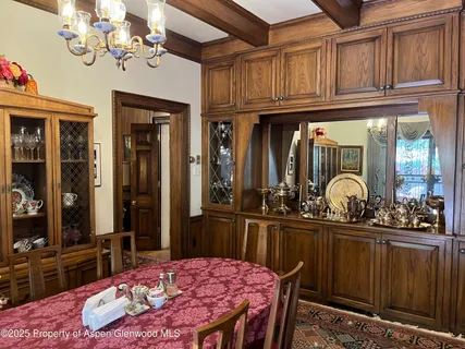 a kitchen with stainless steel appliances a sink dishwasher a dining table and chairs with wooden floor