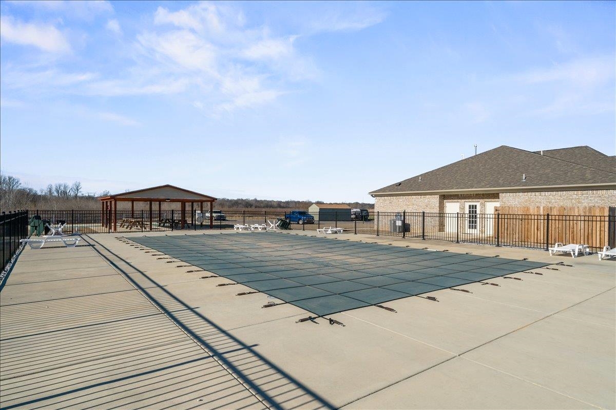415 Abbey Road, Unit D Munford, TN 38058 - Photo 34 of 35 Expansive covered swimming pool with surrounding concrete decking, secured by black metal fencing