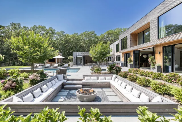 a front view of a house with garden and sitting area