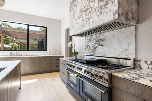 a view of kitchen island with granite countertop lots of appliances