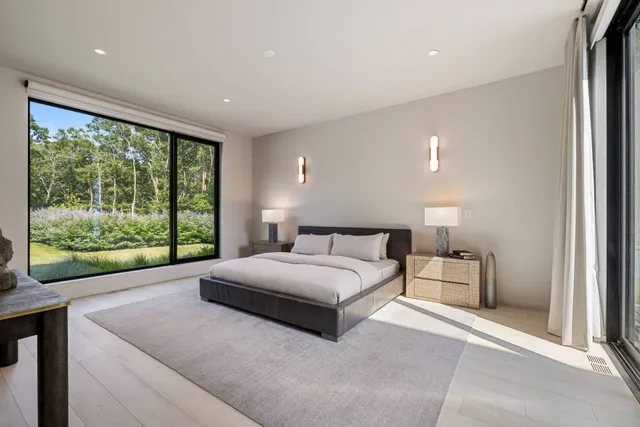 a bedroom with a bed and large window