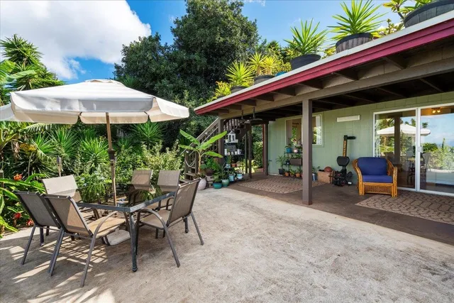 a patio with a table and chairs under an umbrella