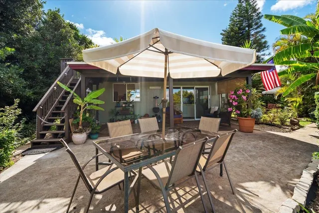 a view of patio with a table and chairs under an umbrella