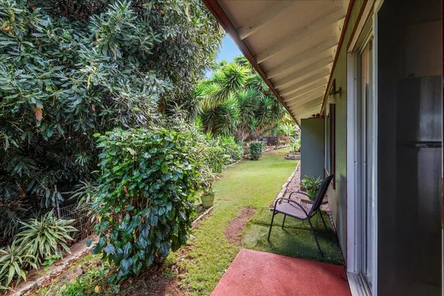 a view of a chair and table in backyard of the house