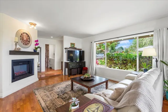 a living room with furniture a flat screen tv and a fireplace