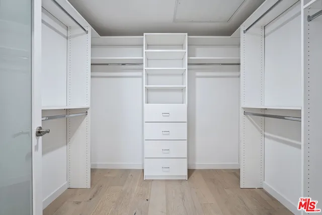a view of walk in closet with empty racks