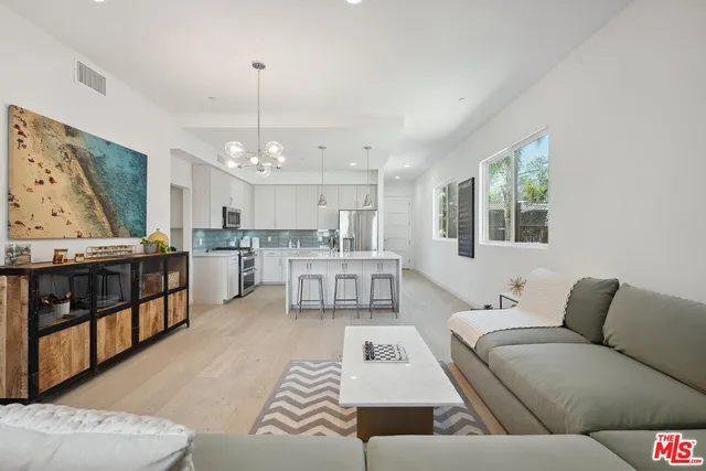 a living room with furniture and kitchen view