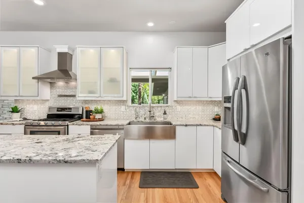 a kitchen with stainless steel appliances granite countertop a refrigerator sink and cabinets