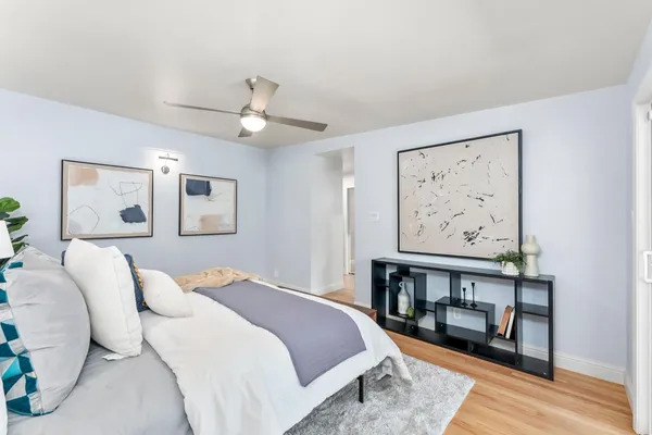 a bedroom with a bed and a painting on the wall