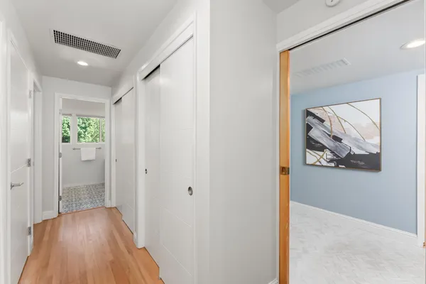 a view of a hallway with wooden floor and closet