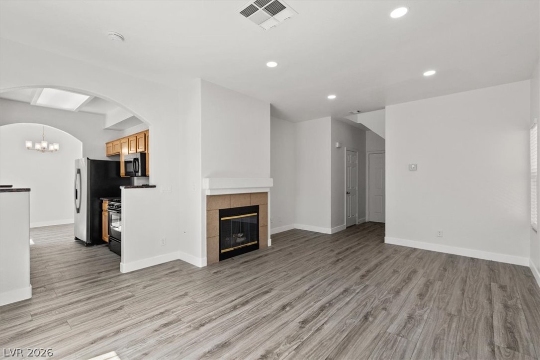 1412 Beaver Spring Street Las Vegas, NV 89128 - Photo 5 of 20 A well-lit interior features a cozy fireplace, seamlessly connecting to an open kitchen space.