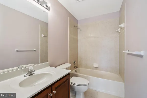 a front view of a building with garden and trees