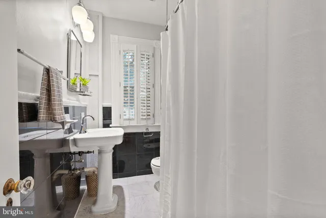 a bathroom with a sink a toilet and mirror