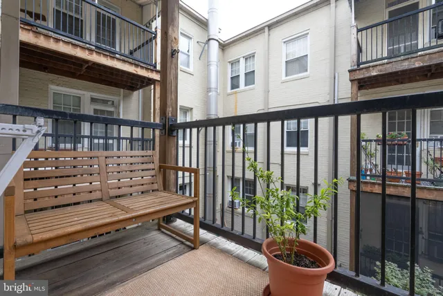 a view of a wooden chairs and iron fence