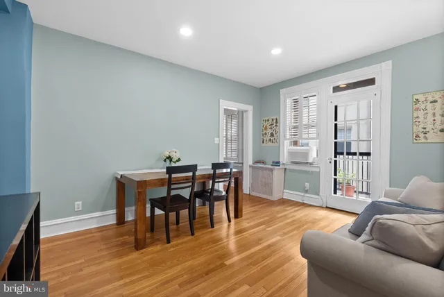 a living room with furniture a wooden floor and next to a window