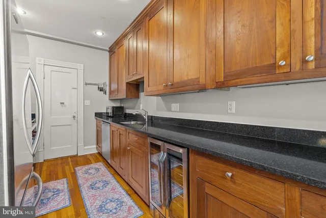 a kitchen with stainless steel appliances granite countertop a refrigerator and a stove top oven